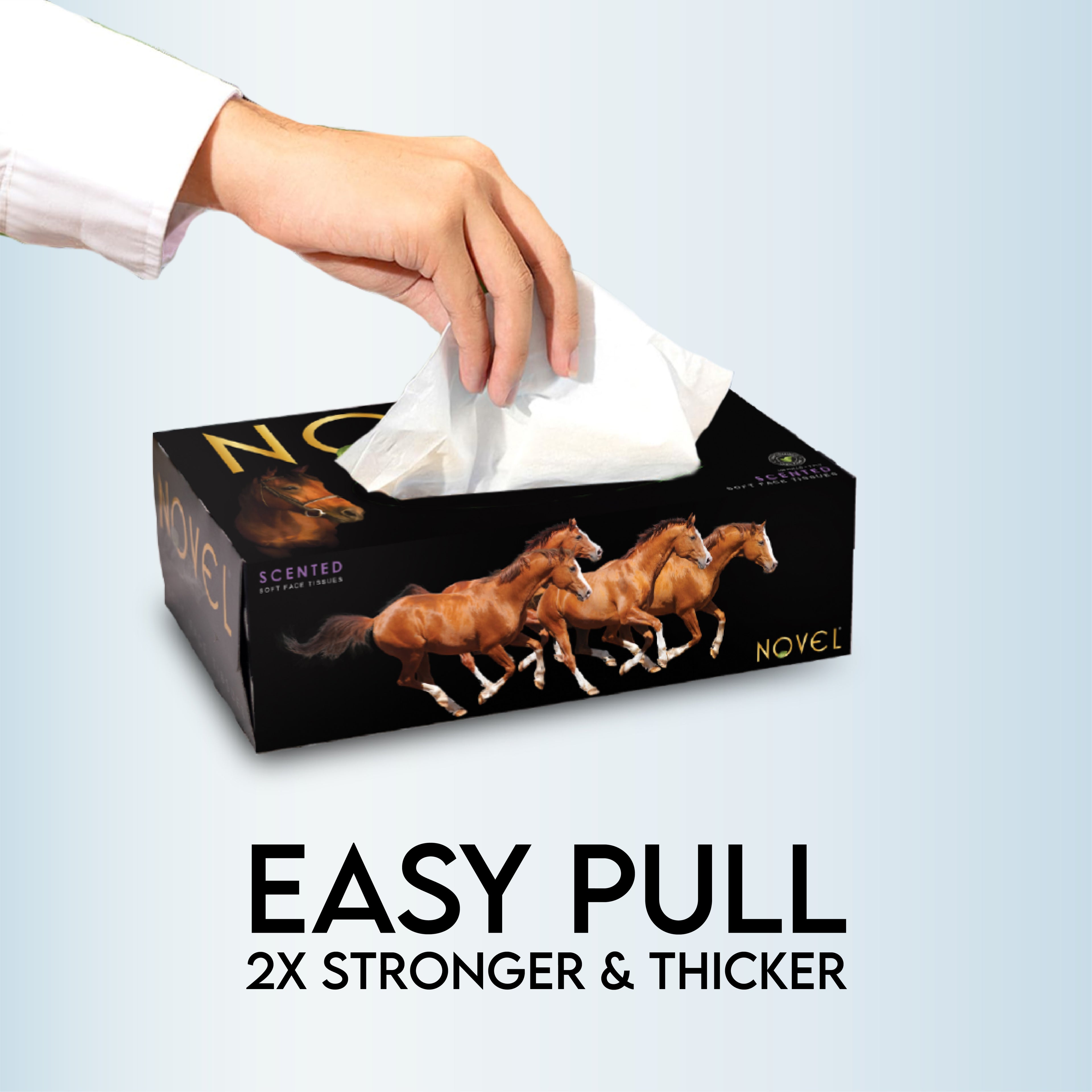 Hand pulling a tissue from a Novel facial tissue box, promoting easy pull feature with 2X stronger and thicker 2-ply tissues